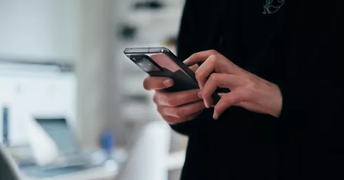 Person using a smartphone in an office setting.